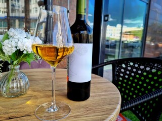 Wine in a glass and in a bottle is on the table