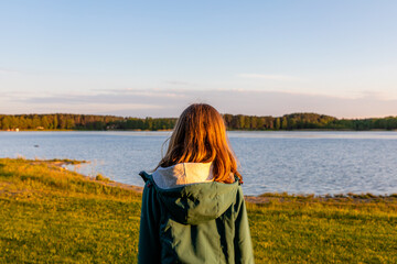 kobieta stojąca na brzegu jeziora