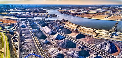 coal handling terminal and storage with windmills in the background - obrazy, fototapety, plakaty