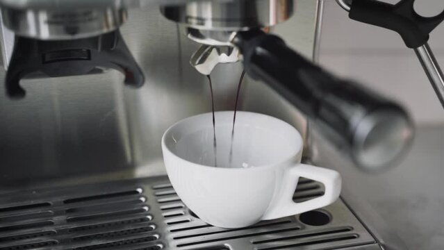 Double shot of espresso pouring into a white cup