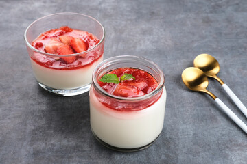 Sweet vanilla silky pudding dessert with strawberry sauce, sliced ​​fresh strawberries and mint on a glass
