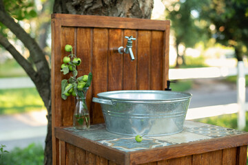Handmade wooden Wash basin with soap in garden for hands cleaning in summer. Hand outdoor washing facilities to prevent the spread of virus or disease. Vintage outdoor sink for rustic decor in yard
