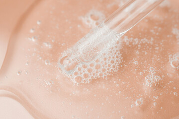Fototapeta premium Transparent cosmetic gel in a Petri dish on a pink background. Laboratory research and development of cosmetic body care products. Close-up - the structure of the gel