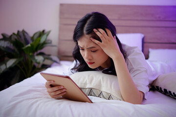 Frowning anxious teenage girl reading distressing news article on tablet computer, doomscrolling concept