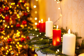 Burning candles on the piano near decorated Christmas tree. Beautiful Christmas background of decorated room with candles and lights