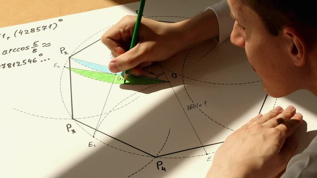 Young mathematician and designer Pavel colouring heptagon with using a green pencil. Date of shooting day 10 May 2022 year, MSK time. This video was filmed in Russia.