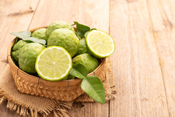 Slice of Thai bergamot on wooden table background. Food and healthcare concept - obrazy, fototapety, plakaty