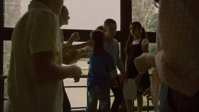 School bullies pushing helpless classmate together standing in circle hallway.