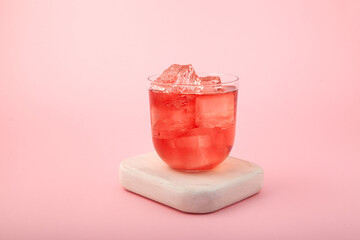 Red summer non-alcoholic drink with ice. Fruit iced tea on pink background. Rose hibiscus refreshing drink © AB-7272