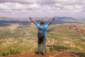A hiker at a scenic view point at Ole Muntus Hill in Sultan Hamud, Kenya