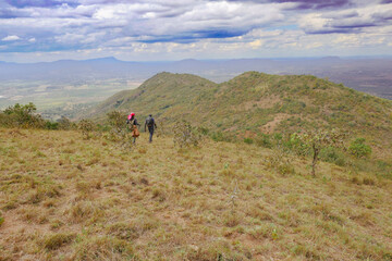 Fototapeta na wymiar A group of hikers against a mountain background at Ole Muntus Hill in Sultan Hamud, Kenya