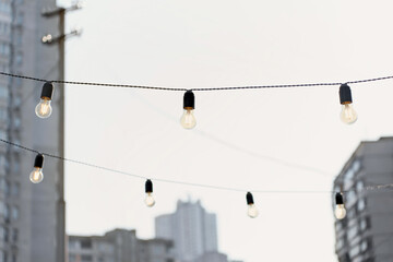 Incandescent lamps on wires in the city