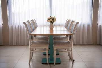 Elegant luxury interior in white colors. Beautiful vintage decoration for wedding, birthday, party or restaurant table set. Decoration with flowers in vase. Natural light.