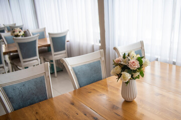 Elegant luxury interior in white colors. Beautiful vintage decoration for wedding, birthday, party or restaurant table set. Decoration with flowers in vase. Natural light.