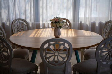 Elegant luxury interior in white colors. Beautiful vintage decoration for wedding, birthday, party or restaurant table set. Decoration with flowers in vase. Natural light.