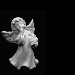 Close up of little guardian angel against black background. Copy space.