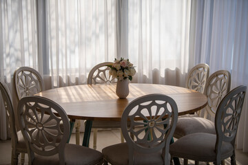 Elegant luxury interior in white colors. Beautiful vintage decoration for wedding, birthday, party or restaurant table set. Decoration with flowers in vase. Natural light.