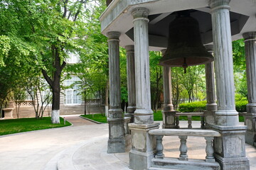 Beijing, China - 05.11.2019 : Stone gazebo with an old bell in the center of the city square.