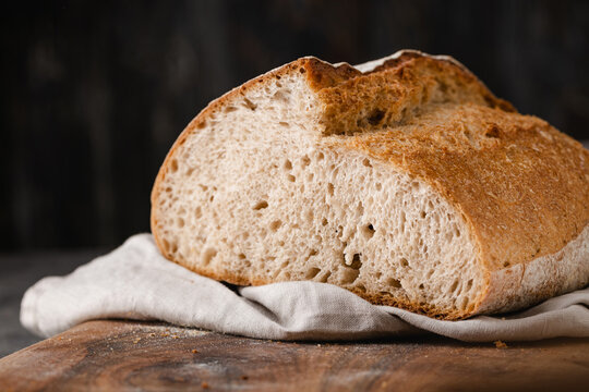 Sourdough loaf of bread on cutting board.