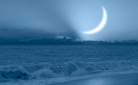 Ramadan Concept - Crescent moon over the sunset clouds with powerful sea wave