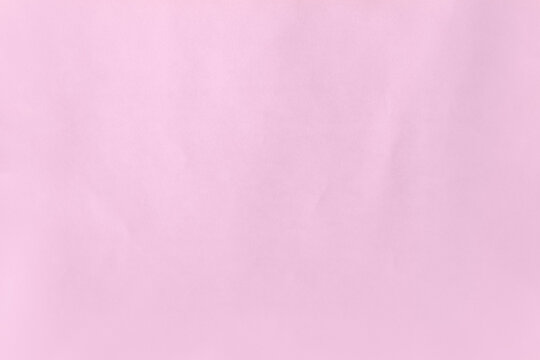 Pale sweet candy plain pink color on recyclable creased blank paper texture background with space