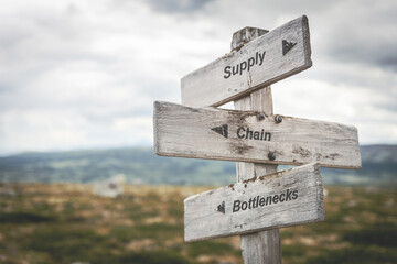 supply chain bottlenecks text quote on wooden signpost outdoors in nature. Inflation, economy and...