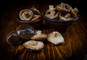 Delicious salted mushrooms on a wooden table . Rustic food . Pickled black gruzd .