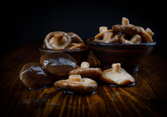Delicious salted mushrooms on a wooden table . Rustic food . Black milk mushrooms on a wooden table .