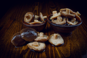 Delicious salted mushrooms . Rustic food .Black milk mushrooms on a wooden table .