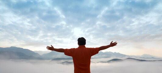 A Man Spread Out His Arms Showing A Beautiful Sea of Clouds with Morning Blue Sky at High Altitude.