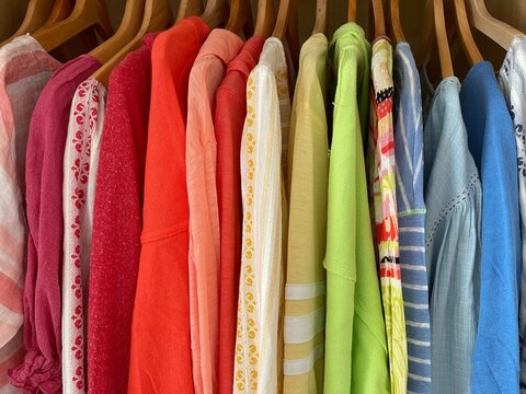 Close-up of a rainbow coloured clothes hanging in a wardrobe