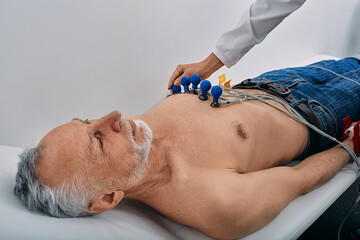 ECG procedure for male patient with electrodes for heart health exam in hospital....