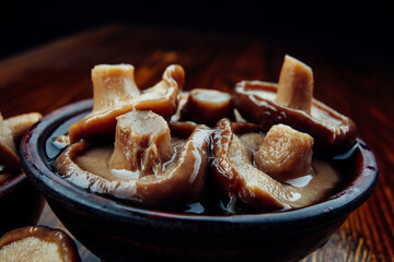 A clay cup full of delicious salted mushrooms . Healthy village food .