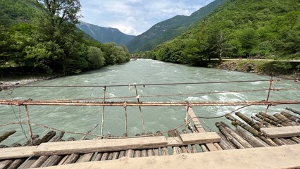 old wooden suspension bridge over the river