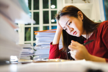 A Stress Woman has a headache during checks reports  during overtime at home