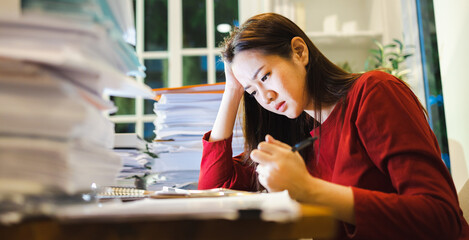 A Headache Woman checks reports during overtime at home
