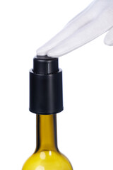 Cropped close-up shot of a men's hand in white gloves pressing a black vacuum stopper into a bottle. The vacuum stopper for wine bottles is on a white background. Front view.