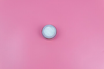 Face cream on a pastel pink background. Top view