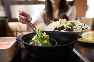 しゃぶしゃぶを食べる女性