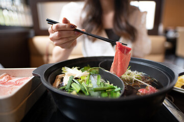 しゃぶしゃぶを食べる女性