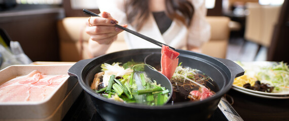 しゃぶしゃぶを食べる女性