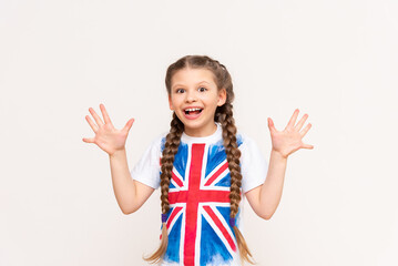 English language courses. A little girl with a big smile with the flag of Great Britain on an...