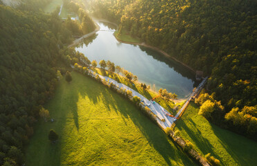 Aerial view of the road and fields and lake at sunrise.