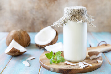 Vegan non dairy alternative milk, health content. Organic coconut milk in a bottle on a rustic table.
