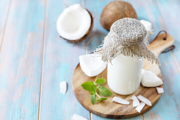 Fototapeta na wymiar Vegan non dairy alternative milk, health content. Organic coconut milk in a bottle on a rustic table. Copy space.