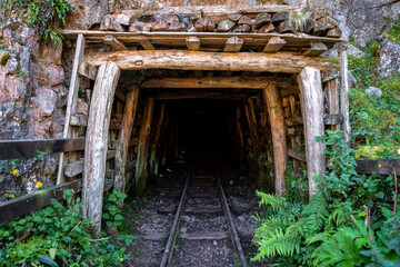 entrance to an old mining cave with rails for a wagon
