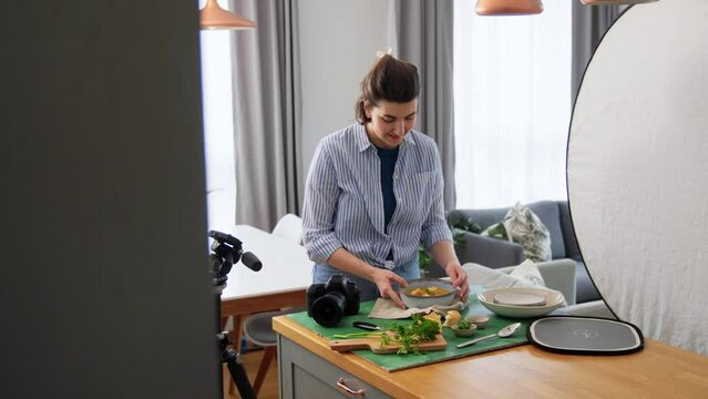 blogging, profession and people concept - female photographer with camera photographing food in kitchen at home