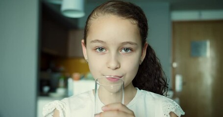 Cute Child Girl Drinking Glass Fresh Transparent Pure Filtered Mineral Water at Home. Slow Motion Little Girl Drinks Water. Closeup Kid drinking Cup Water Healthy Body Care. Healthy lifestyle Children