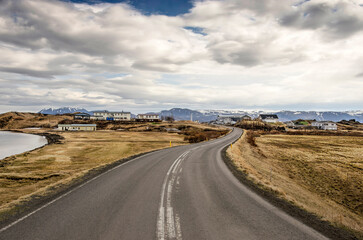 Skutustadhir, Iceland, April 29, 2022: curving asphalt road to the village on the edge of the pseudocrater area on the southern shore of lake Myvatn