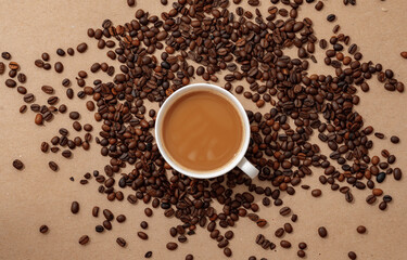Cup of coffee with coffee beans on paper background. Top view